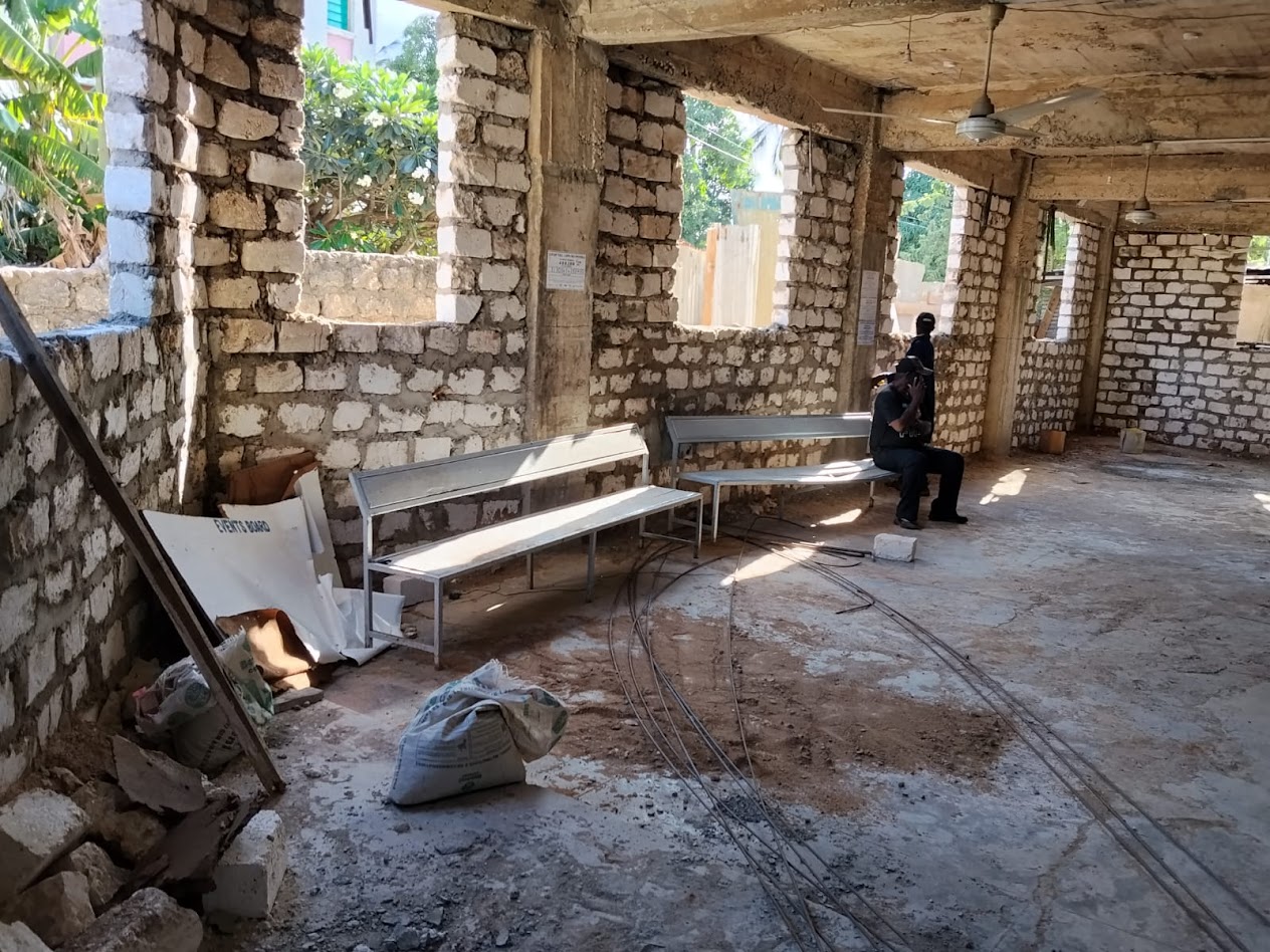 Multiplex interior under construction with coral-stone walls and benches