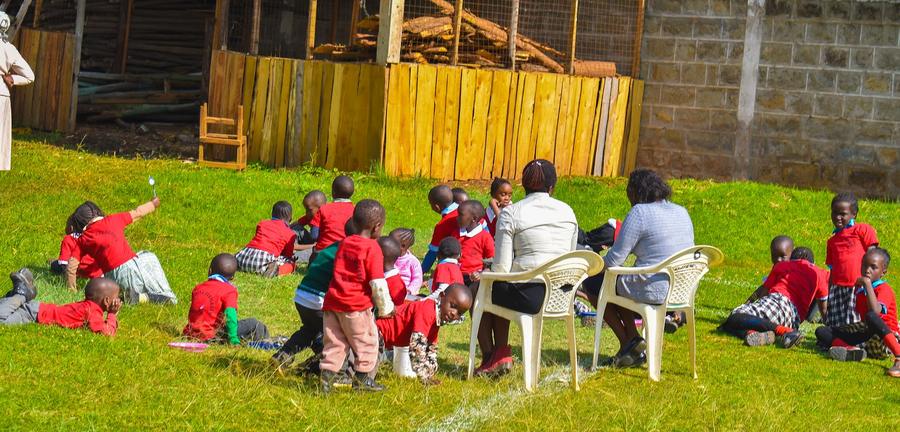 St. Rita students in red uniforms at outdoor lesson on the grass — Nyahururu Kenya GDP supported school