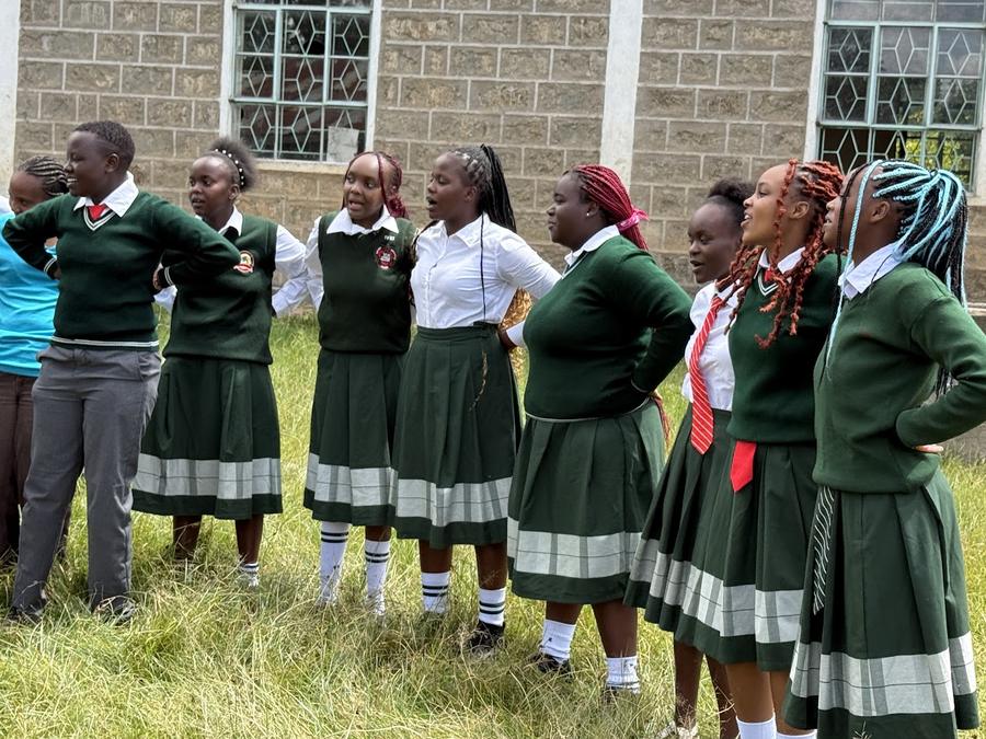 St. Rita Evergreen Girls School students singing and performing together outdoors — joy at Nyahururu, Kenya