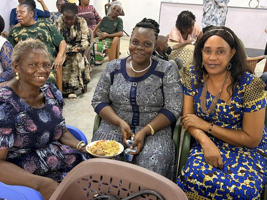 Three women enjoying a meal together at GDP Women's Empowerment conference — including woman in blue and navy dress, Kenya